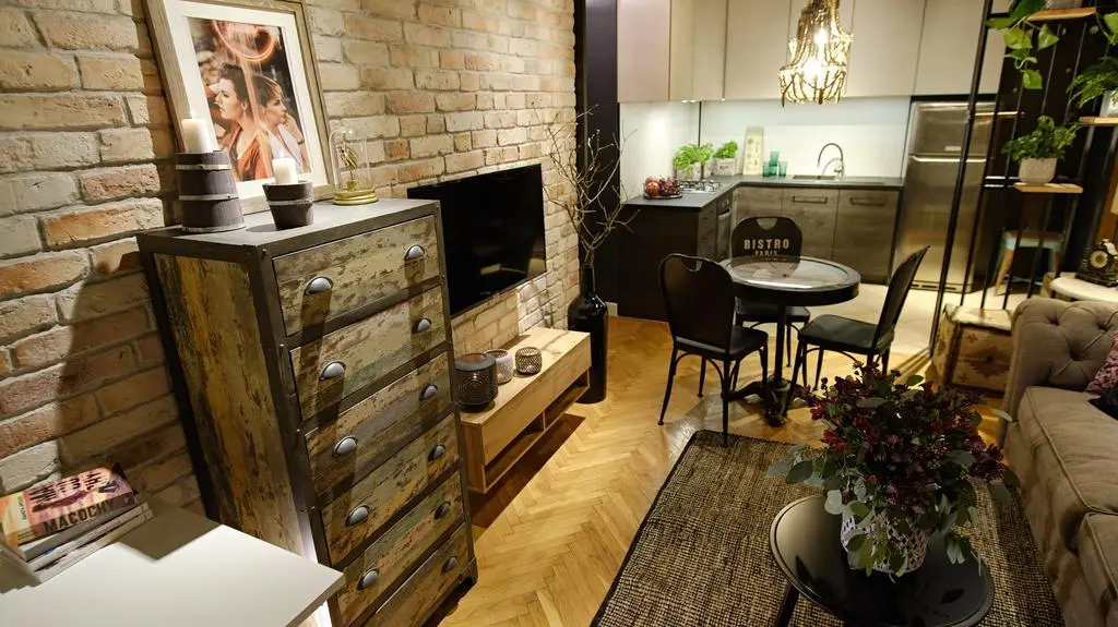 Wygodna sofa z małym stoliczkiem kawowym zachęcają do relaksu przed telewizorem.