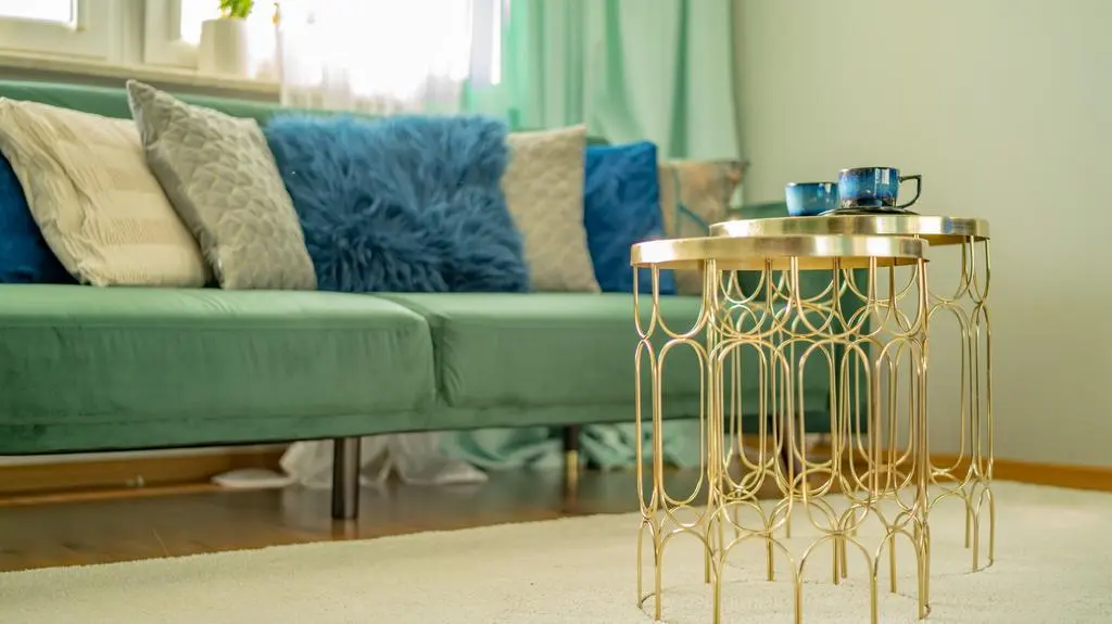Zamiast dużego, ciężkiego narożnika w salonie Dagmary i Karola stanęła elegancka, rozkładana sofa w kolorze zgaszonej zieleni. Nóżki dodają jej lekkości, a kolorowe poduszki sprawiają, że kanapa idealnie wkomponowała się w to pomieszczenie.