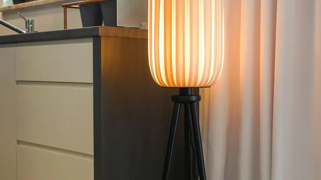 Stojąca lampa koresponduje swoją formą ze stolikami kawowymi stojącymi przy kanapie.