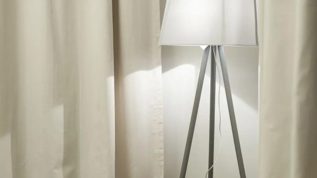 Biała lampa wtapia się w ścianę, ale doświetla duże pomieszczenie.