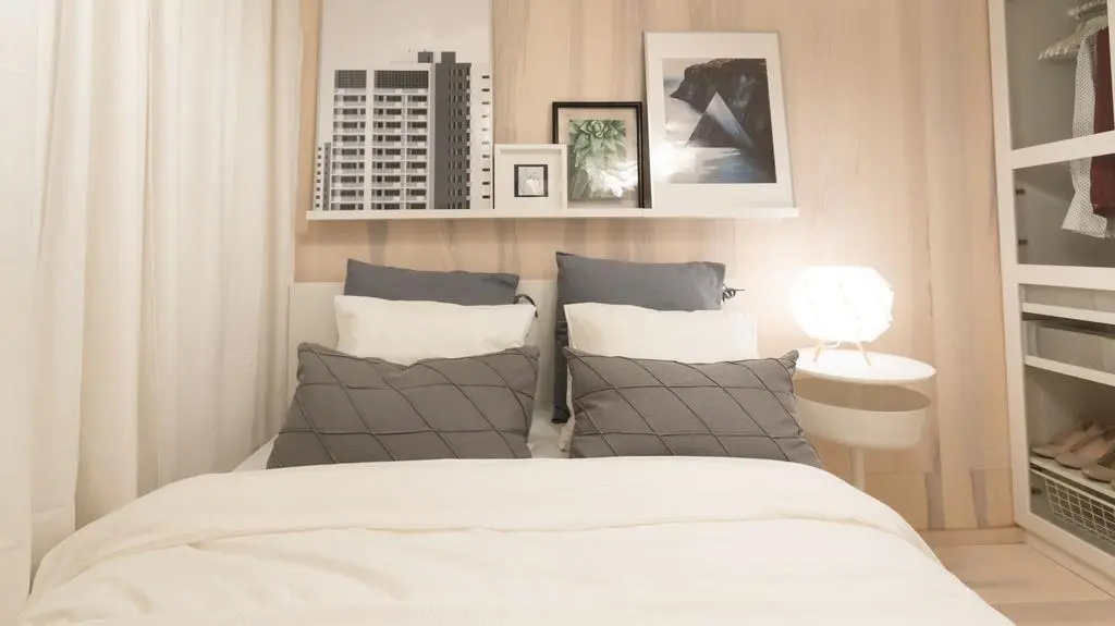 Łóżko stanęło tuż przy oknie. Zostało pościelone w stylu hotelowym, czyli z dużą ilością poduszek w pasujących do siebie kolorach.