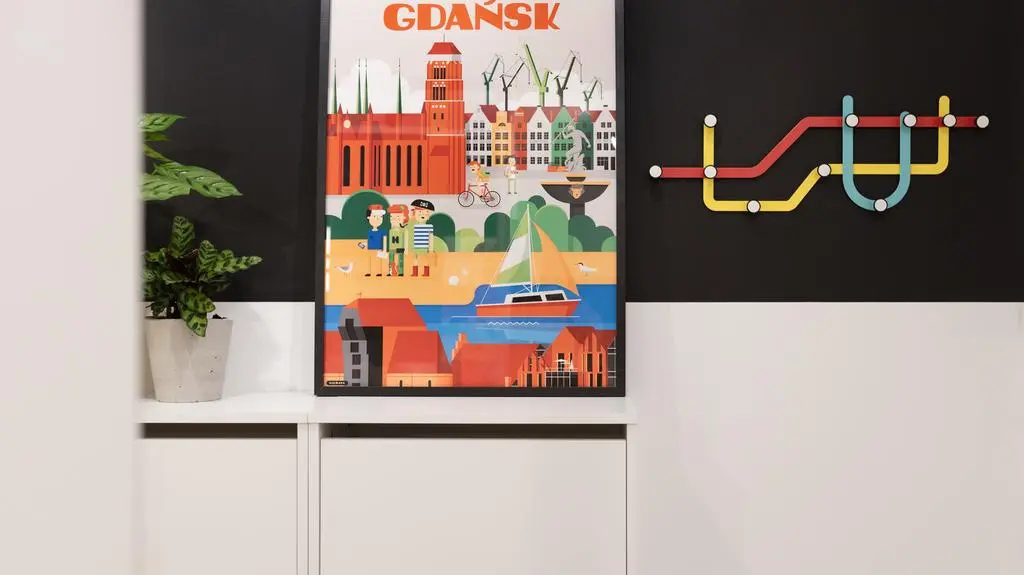 Pomysłowe projekty: kolorowy wieszak i plakat na tle czarnej ściany   