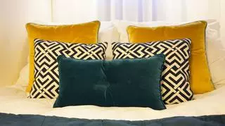 Przytulną sypialnię tworzą różnokolorowe poduszki.