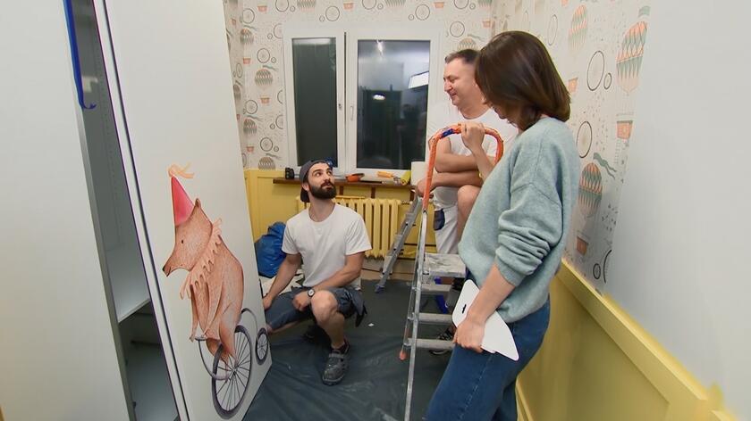 W swoich aranżacjach w programie "Pomysłowe projekty" Iwona Durka zawsze stara się pokazać, że nie trzeba ogromnych nakładów pieniędzy, aby dokonać całkowitej metamorfozy wnętrza i pięknie urządzić przestrzeń. W 3. odcinku swojego formatu architektka tworzyła pokój dla dwójki małych dzieci: Alicji i Wincenta. Projektując, postanowiła wykorzystać szafę, którą zastała w sypialni rodziców maluchów. Mebel nie był zniszczony, spełniał swoje funkcje i mógł pomieścić wiele zabawek czy ubrań rosnących latorośli. By dostosować go do pokoju dzieci, postanowiła nieco go odświeżyć za pomocą naklejki z niedźwiedziem na rowerku. Jej przyklejenie nie jest wcale takie łatwe ani oczywiste. Iwona Durka poprosiła o pomoc szefa swojej ekipy remontowej - Szymona Pasierowskiego. Razem pokazali, jak należy przykleić taką naklejkę, aby wyglądała dobrze. 