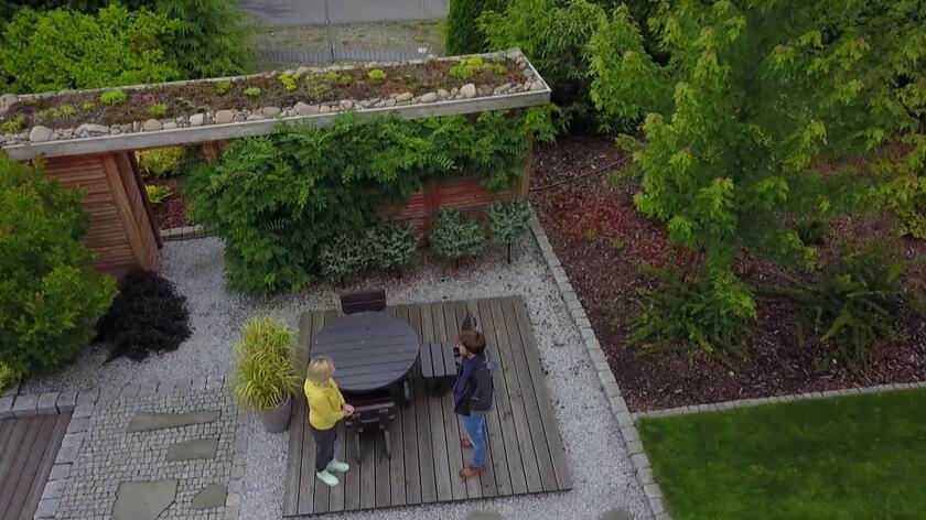 Domy, w których są kominki, wymagają wygospodarowania w budynku lub obok niego miejsca do przechowywania drewna. W ogrodzie przy połączonych domach zamieszkiwanych przez trzy rodziny powstała drewutnia. Pełni ona nie tylko funkcję praktyczną, ale i ozdobną. Jest porośnięta wisterią i osłonięta szczepionymi na niskich pniach świerkami kłującymi. Również jej dach porastają rośliny. Cała konstrukcja to nie tylko miejsce do przechowywania drewna, ale także ścianka oddzielająca niewielki taras od pobliskiej drogi.